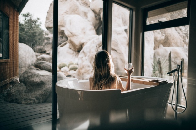 A girl in a bathtub with a wine glass in her hand