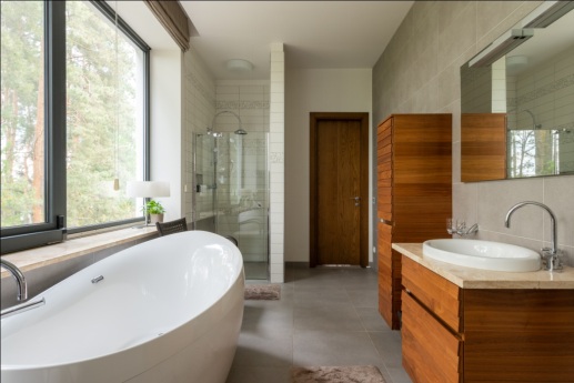 A bathroom with large windows and a clean white bathtub