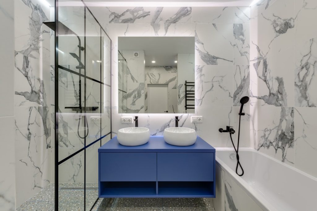 Bathroom with white marble pattern ceramic and blue cabinets