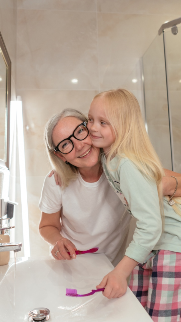 A woman hugging a girl in bathroom