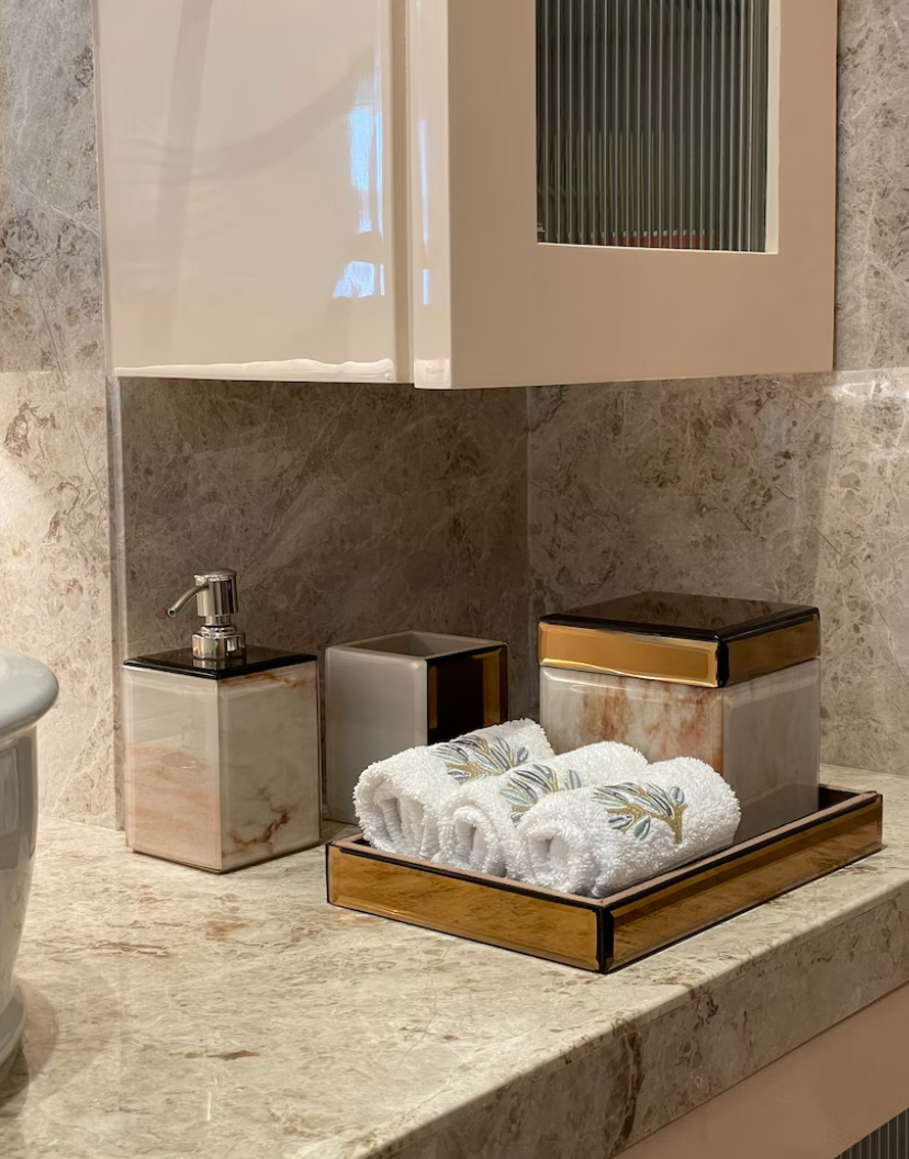 A tray with rolled towels and a soap dispenser in the bathroom